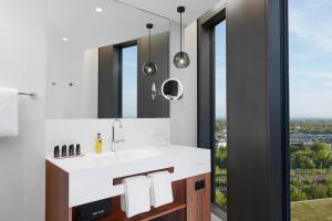 un bagno con lavandino e specchio di HYPERION Hotel München a Monaco