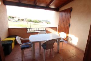 a table and chairs in a room with a window at Appartamenti Paradise in Cannigione