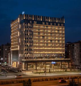 a tall building with a parking lot in front of it at Movenpick Diyarbakir in Diyarbakır