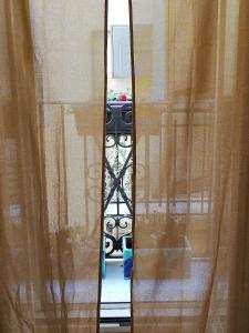 - une vue sur un miroir à travers une fenêtre avec des rideaux dans l'établissement Cassiopea, à Gaète