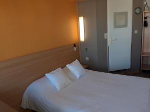 
a hotel room with a white bed and white walls at Premiere Classe Liege / Luik in Liège
