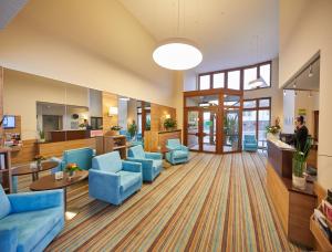 sala de estar con sillas azules y vestíbulo en Hotel Filderland - Stuttgart Messe - Airport - Self Check-In, en Leinfelden-Echterdingen