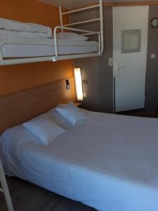 
a bedroom with a bed and a lamp at Premiere Classe Liege / Luik in Liège
