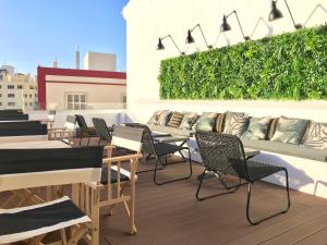 a patio with chairs and tables on a roof at Alameda Exclusive House in Faro