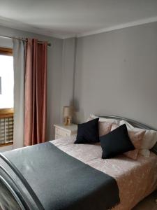 a bedroom with a large bed with black pillows at Apartamento Markinca in Vilamoura