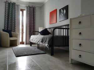 a bedroom with a bed and a dresser and a chair at Apartamento Markinca in Vilamoura