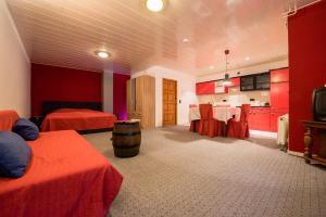 um quarto de hotel com duas camas e paredes vermelhas em Weinschlößchen im Weingut Roos em Ilbesheim