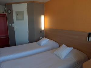 two beds sitting next to each other in a room at Premiere Classe Liege / Luik in Liège