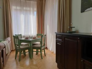 a green table and chairs in a room with a window at City Center Premium Belle Vue Apartments in Timişoara +9 photos