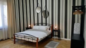 a bedroom with a bed and a striped wall at City Center Premium Belle Vue Apartments in Timişoara