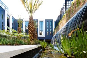 un patio con palmeras y un edificio en The Weinberg Windhoek, en Windhoek
