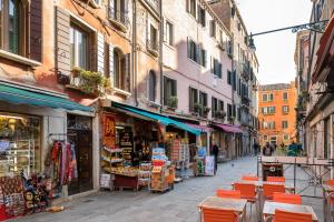 une rue avec des tables et des chaises dans une rue de la ville dans l'établissement Venice Heaven Apartments Biennale, the Elegant Residence, à Venise
