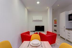 un soggiorno con tavolo e sedie rosse e gialle di Cozy Apartment in an Amazing Location a Sliema