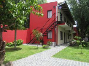 un edificio rojo con una escalera delante en La Casona en Gualeguaychú