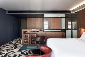 a bedroom with a bed and a desk and a kitchen at AthensWas Design Hotel in Athens