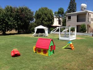a group of toys on the grass in front of a house at Constantaras Apartments in Protaras