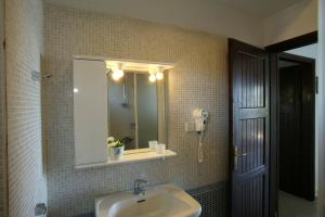 a bathroom with a sink and a mirror and a phone at Lagonisi Beach Resort in Ormos Panagias +33 photos