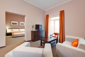 a living room with two white couches and a television at Lviv Ramada Hotel in Lviv