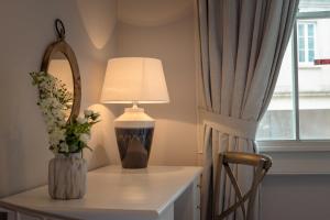 a table with a lamp and a vase of flowers on it at Anabelle's Guest House in Bath
