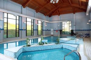 an indoor pool with a large swimming pool at Roe Park Resort in Limavady
