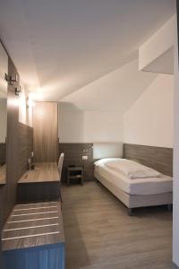 a bedroom with two beds and a desk in it at Hotel Garnì Villa Fontana in Trento