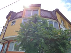 a yellow house with a tree in front of it at Hotel Le Village in Skopje