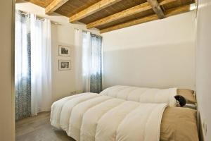 1 Schlafzimmer mit 2 Betten in einem Zimmer mit Holzdecken in der Unterkunft CaseOspitali - CASA CARAMELLI bilocale in corte storica in Cernusco sul Naviglio