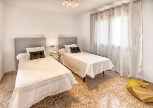 a bedroom with two beds and a window at Villa Romaní in Sa Pobla +32 photos