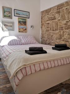 sypialnia z 2 łóżkami i kamienną ścianą w obiekcie Apartment Ana w mieście Vis