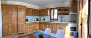 eine Küche mit Holzschränken sowie einem Tisch und Stühlen in der Unterkunft Apartment Blue Bay in Malinska
