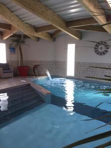 uma grande piscina com uma fonte de água em Hôtel Calme Des Pins & Spa em Les Sables-dʼOlonne