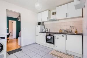 a white kitchen with white appliances and a room at Grand T2 50m2 - 10min Paris Orly - Jacuzzi - Fan in Alfortville +23 photos