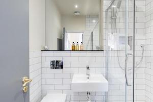 uma casa de banho branca com um lavatório e um chuveiro em The Heaton at Claremont Serviced Apartments em Leeds