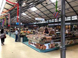 a farmers market with people walking around a store at Two bedroom apartment near beach and Casino in Figueira da Foz