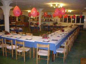 een lange tafel met stoelen en rode ballonnen bij Zi Bak in Ischia