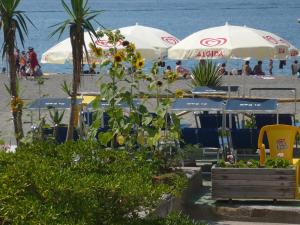 een strand met parasols en mensen op het strand bij Zi Bak in Ischia
