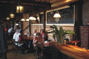 un grupo de personas sentadas en mesas en un restaurante en Landgasthof am Bäumchen, en Weissenfels