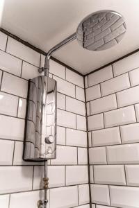 a bathroom with a mirror on a white tiled wall at Brighton Erotic Boudoir in Brighton & Hove