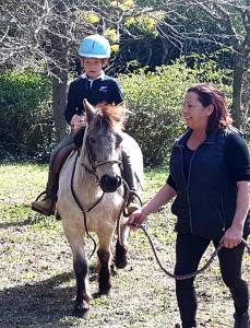 Una mujer llevando a un niño a caballo en Féerie Love, en Puget-sur-Argens