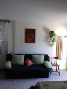 a living room with a green couch and a table at Anita studio 3 Apartment in Mali Lošinj