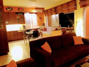 ein Wohnzimmer mit einem Sofa und einer Küche in der Unterkunft Ruby's house in Chalkida