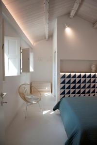 a bedroom with a bed and a chair in it at 4 Elements Boutique Home in Siracusa