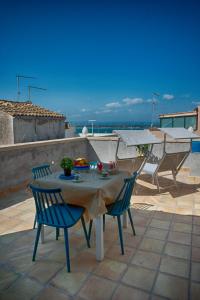 a table and chairs on a patio with a view of the ocean at 4 Elements Boutique Home in Siracusa