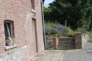 uma parede de tijolos com dois vasos de plantas ao lado de um edifício em Une Maison à la Campagne em Durbuy