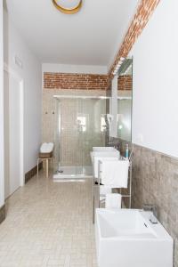 La salle de bains est pourvue de 2 lavabos et d'une douche. dans l'établissement Le Suite, à Polistena
