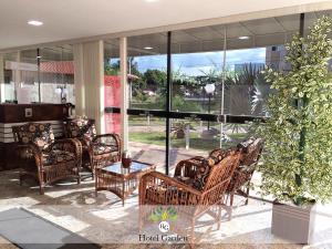 un vestíbulo con sillas de mimbre y una mesa en Hotel Garden, en Santa Maria 20 fotos más