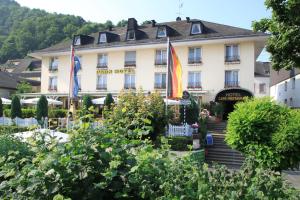 a hotel with flags in front of a garden at Park-Hotel Traben-Trarbach in Traben-Trarbach