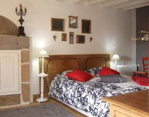 una camera da letto con un letto con cuscini rossi di Chambre des Anges & Roulotte proche Mont Saint-Michel, l'Angevinière a Saint-Laurent-de-Terregatte