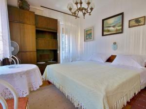a bedroom with a large white bed and a table at Guest house Ribaric in Rab