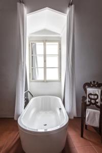 a white bath tub in a bathroom with a window at Design Hotel Neruda in Prague